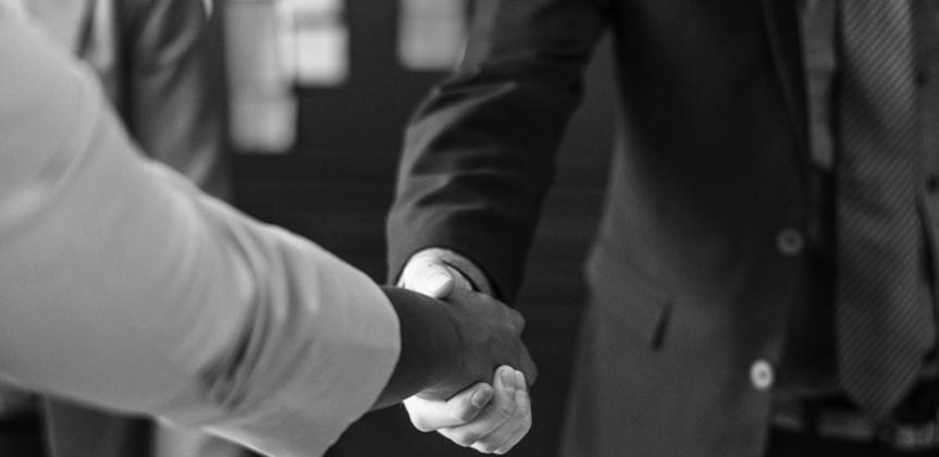 Two person shaking hands in grayscale photo