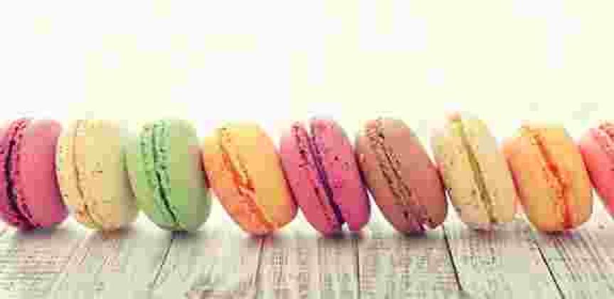 a horizontal row of colorful sandwich cookies shaped like hamburgers