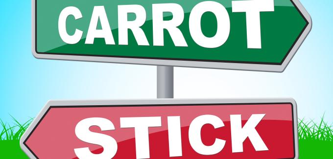 Directional signs pointing to the right and to the left with the words: Carrot and Stick