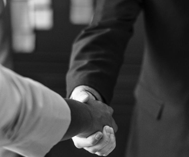 Two person shaking hands in grayscale photo