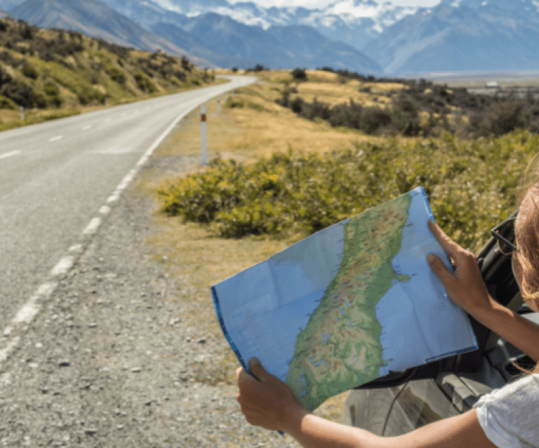 Person holding map by the road
